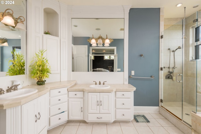 bathroom with a shower with shower door, vanity, and tile floors