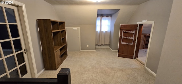 interior space with light colored carpet and lofted ceiling