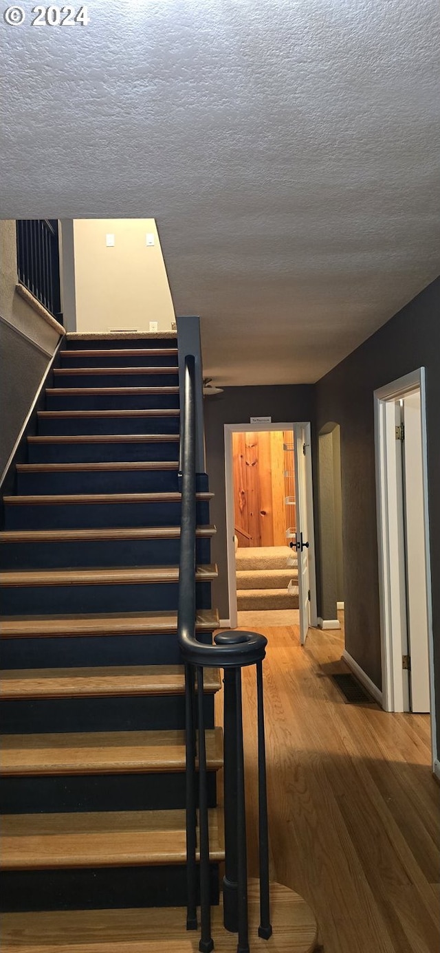 interior space featuring hardwood / wood-style flooring and a textured ceiling