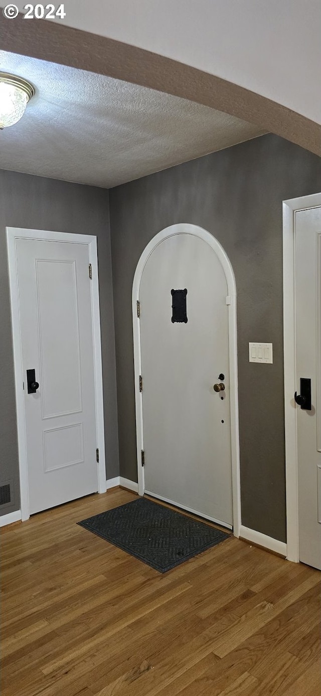 entrance foyer with a textured ceiling and hardwood / wood-style floors