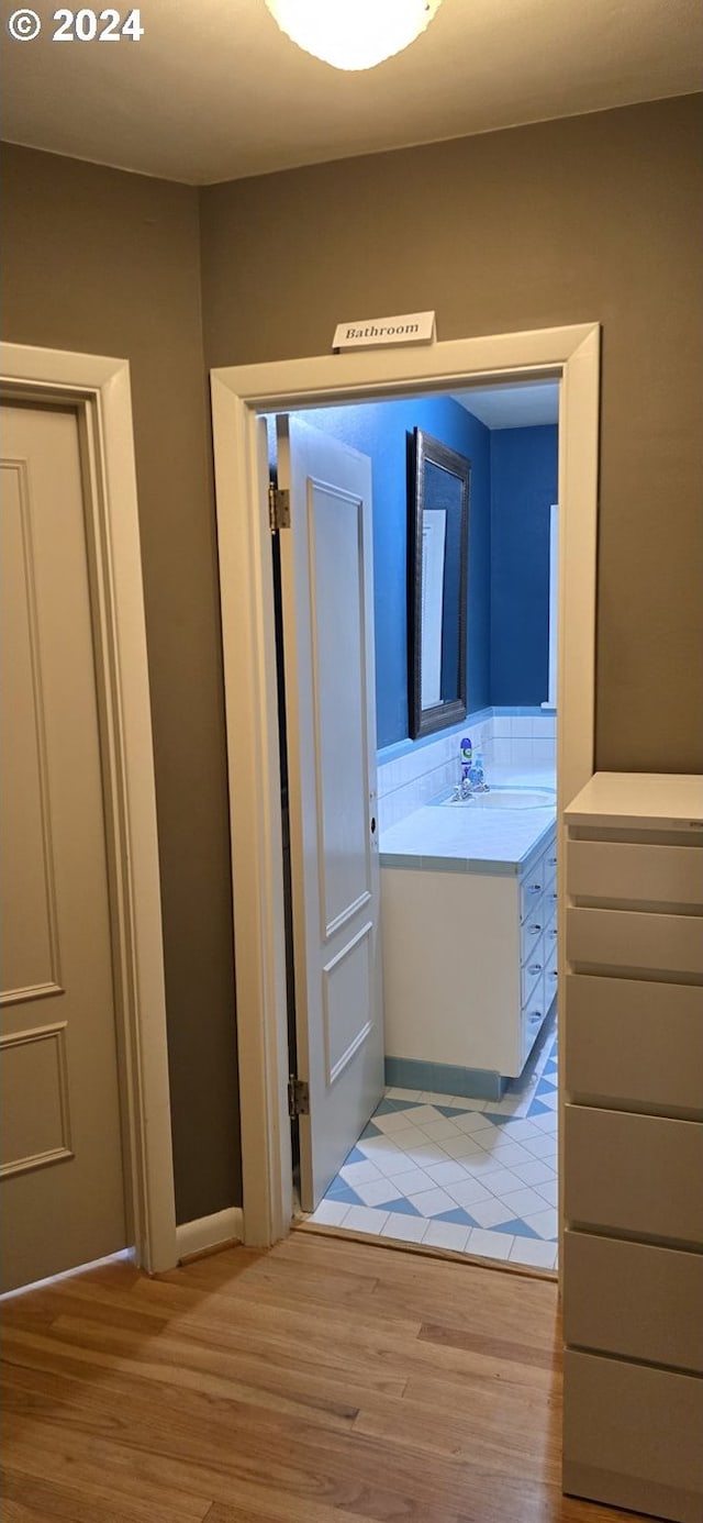 bathroom featuring hardwood / wood-style flooring, backsplash, and vanity