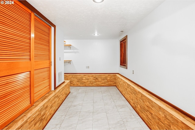 tiled spare room with a textured ceiling