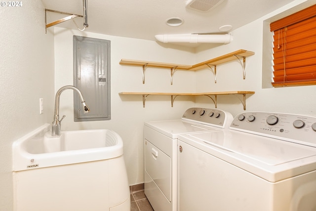 washroom featuring washing machine and clothes dryer, tile patterned flooring, and electric panel