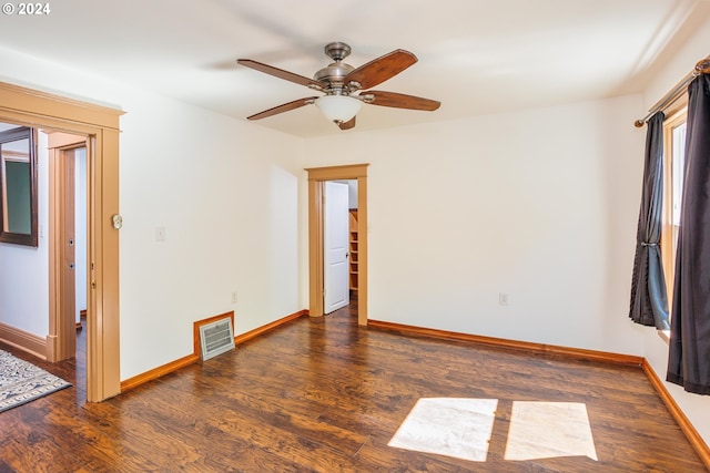 empty room with ceiling fan and dark hardwood / wood-style flooring