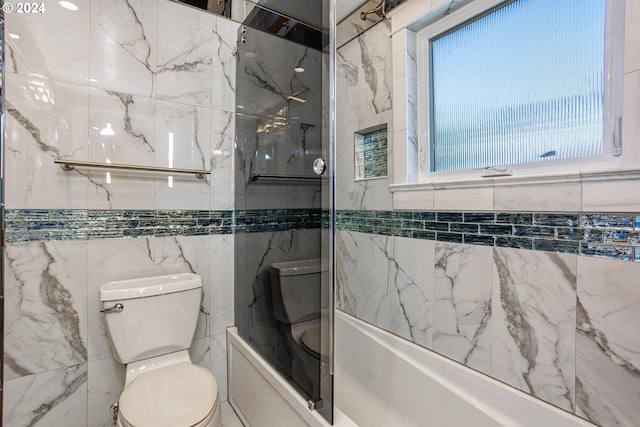 bathroom featuring tile walls, tiled shower / bath, and toilet