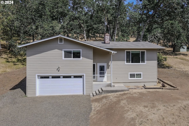 raised ranch with a garage and a chimney