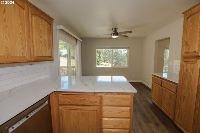 kitchen featuring light stone counters, a peninsula, dark wood-style floors, decorative backsplash, and dishwasher