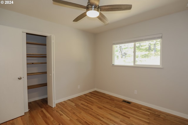 unfurnished bedroom with light hardwood / wood-style flooring, ceiling fan, and a closet