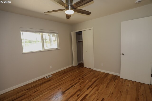 unfurnished bedroom featuring ceiling fan, a closet, and hardwood / wood-style floors