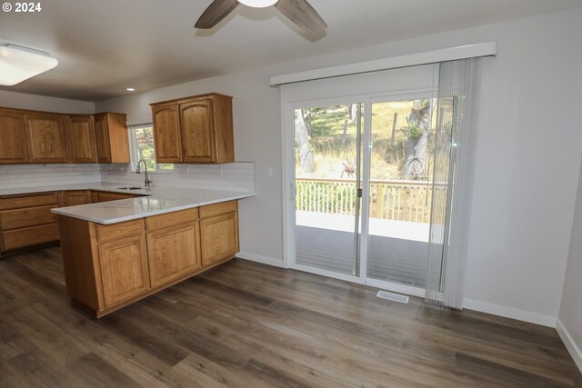 kitchen featuring sink, decorative backsplash, dark hardwood / wood-style floors, and ceiling fan