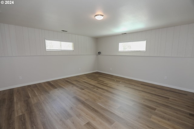 unfurnished room featuring a wealth of natural light, baseboards, and wood finished floors