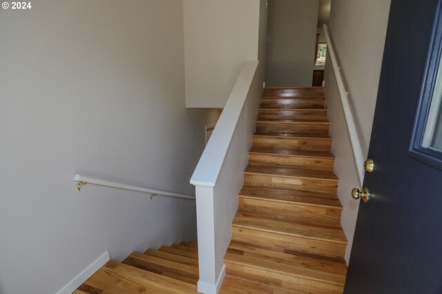 stairs featuring hardwood / wood-style floors