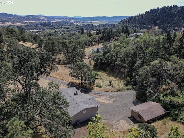 drone / aerial view featuring a mountain view and a wooded view