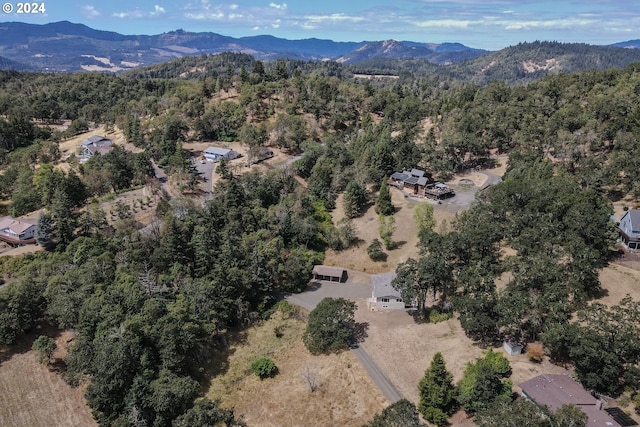 birds eye view of property featuring a mountain view and a view of trees