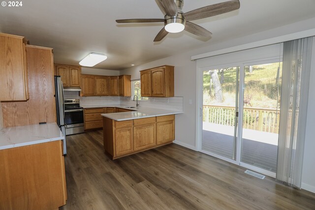 kitchen with stainless steel electric stove, dark wood-type flooring, tasteful backsplash, ceiling fan, and kitchen peninsula