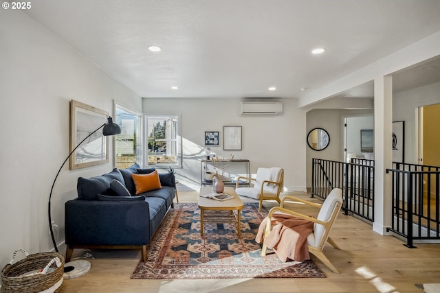 living room with light wood-type flooring and an AC wall unit