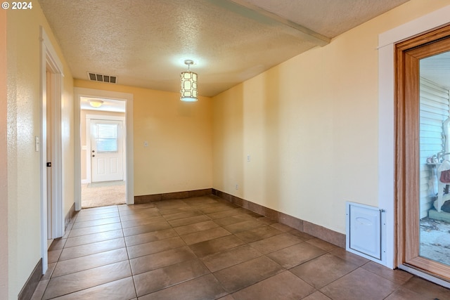 unfurnished room featuring tile patterned floors and a textured ceiling