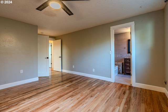 empty room with ceiling fan, light hardwood / wood-style flooring, and a textured ceiling