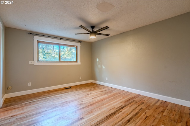 spare room with ceiling fan, light hardwood / wood-style flooring, and a textured ceiling