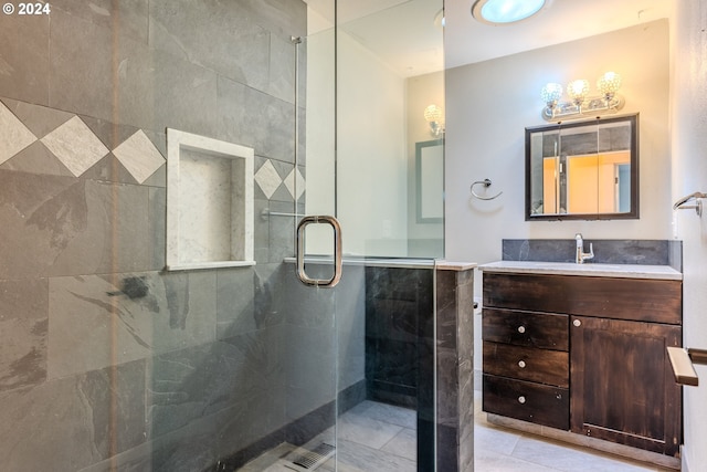 bathroom with walk in shower, vanity, tile walls, and tile patterned flooring