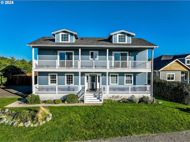 view of front of property with a balcony, a front lawn, and covered porch