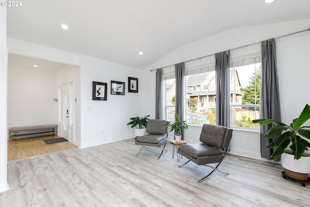 living area featuring light hardwood / wood-style floors and vaulted ceiling