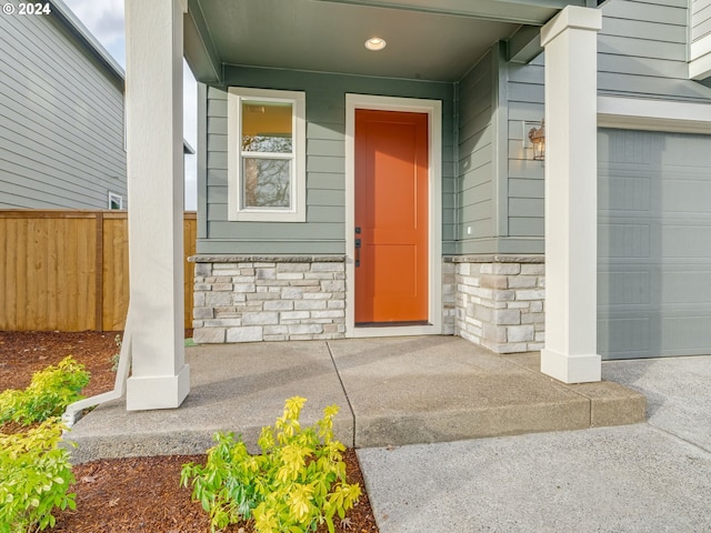 property entrance featuring a porch and a garage