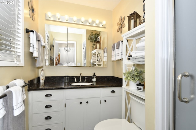 bathroom with walk in shower, vanity, and toilet