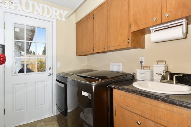 clothes washing area featuring cabinets, washing machine and dryer, and sink