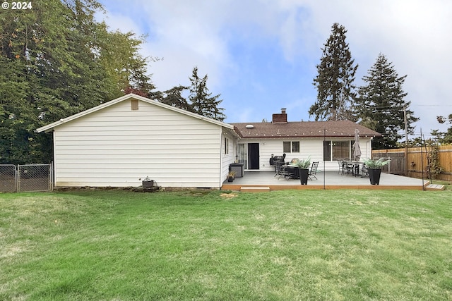 back of property with a wooden deck and a lawn