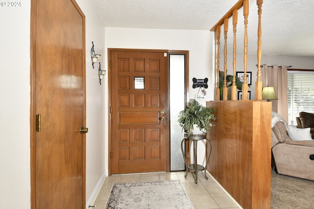 tiled entryway with a textured ceiling