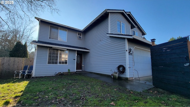 rear view of property with a garage and a lawn