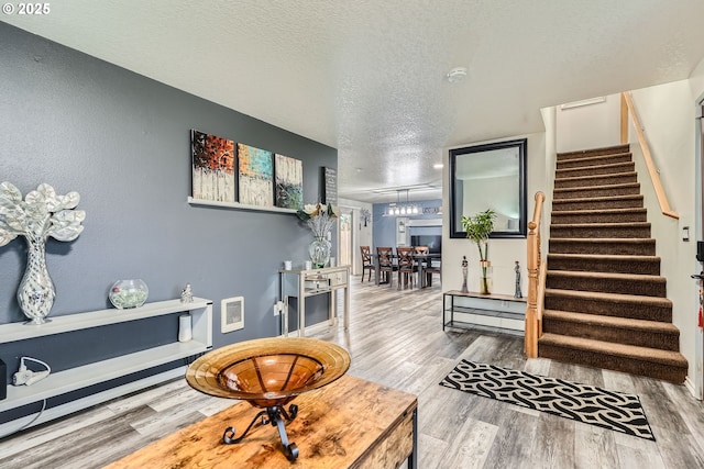 interior space with stairway, a textured ceiling, and wood finished floors