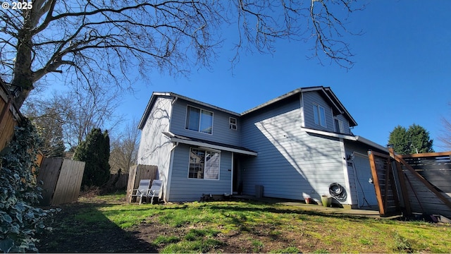 view of front facade featuring an attached garage, fence, and a front yard