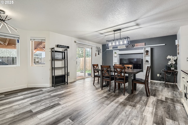 dining room featuring a textured ceiling, baseboards, and wood finished floors