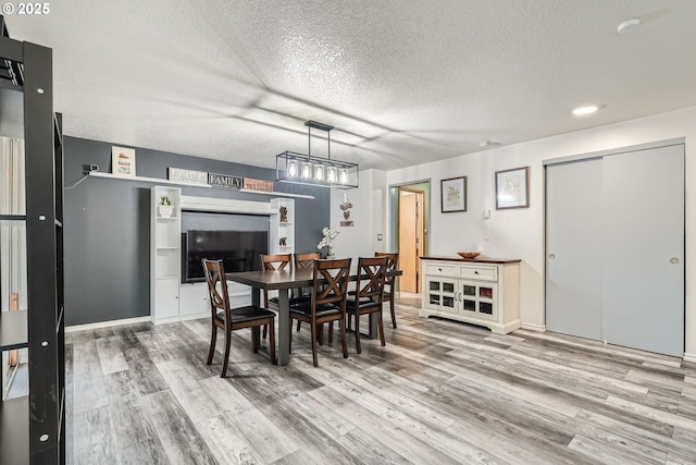 dining area featuring a textured ceiling and wood finished floors