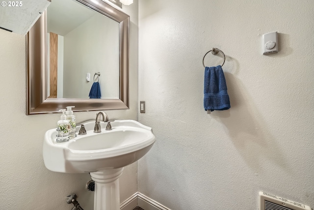 bathroom featuring a textured wall