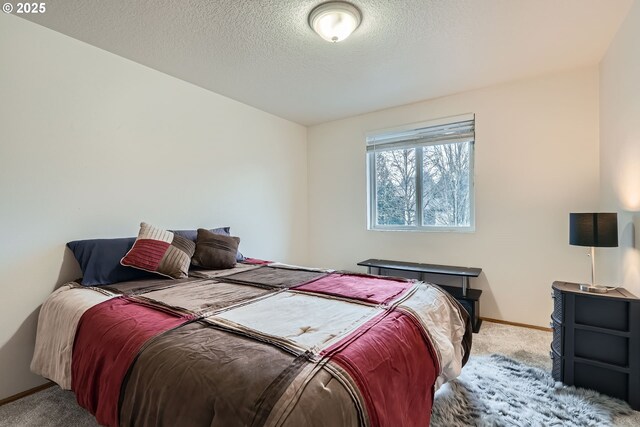 carpeted bedroom with a textured ceiling and baseboards