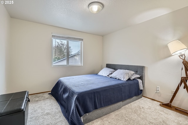 carpeted bedroom featuring a textured ceiling and baseboards