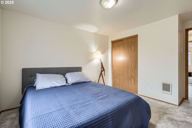 carpeted bedroom featuring a closet, a textured ceiling, and baseboards