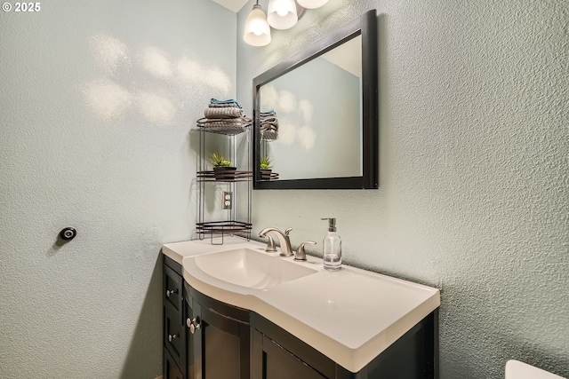 bathroom featuring a textured wall and vanity