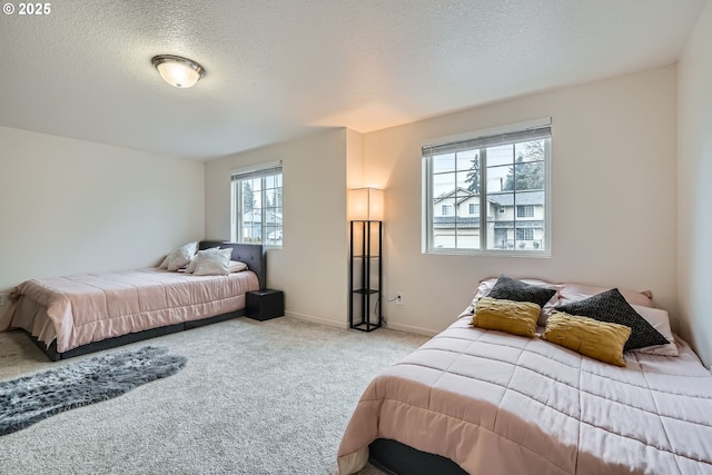 carpeted bedroom with a textured ceiling and baseboards