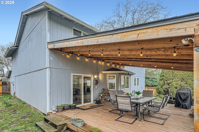 deck featuring outdoor dining space and grilling area