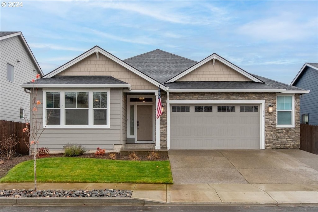 craftsman-style home with a front lawn and a garage