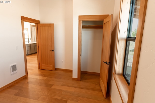 unfurnished bedroom with a closet, light hardwood / wood-style flooring, and sink