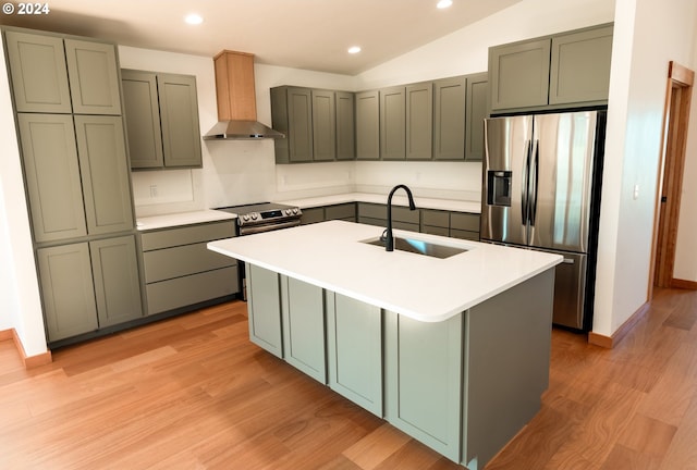 kitchen with appliances with stainless steel finishes, a kitchen island with sink, sink, wall chimney range hood, and lofted ceiling