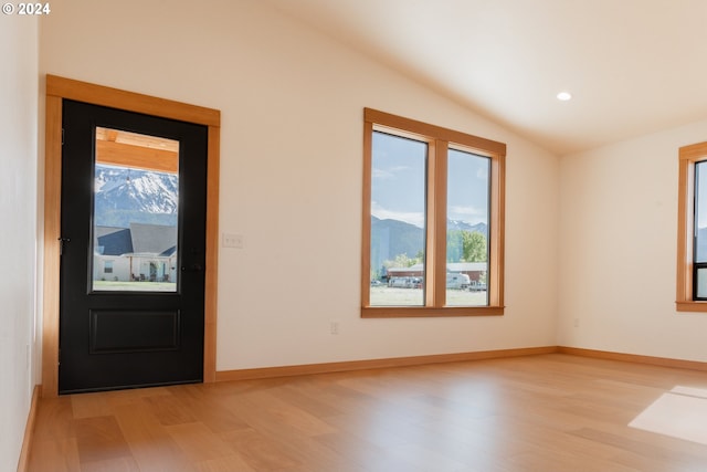 entrance foyer featuring plenty of natural light, a mountain view, light hardwood / wood-style flooring, and vaulted ceiling