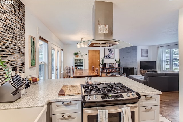 kitchen with white cabinetry, island range hood, and stainless steel gas stove