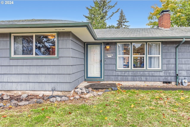 doorway to property with a yard