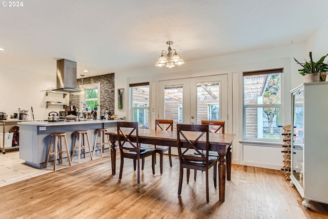 dining space featuring light wood-type flooring and a notable chandelier